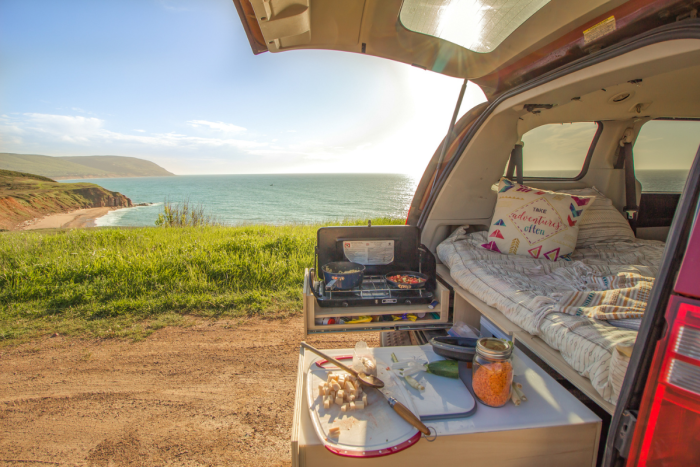 Hidden and ultra-functional kitchen in the Roadloft minivan kit with retractable sink, optimized drawers, and integrated cutting board for a compact and practical setup.